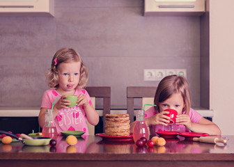 Pancake week. Little girls (sisters) eat pancakes.