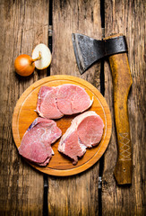 Fresh raw meat with spices and chopping axe.