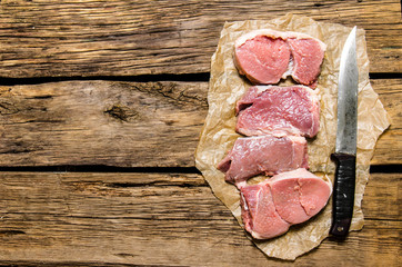 Medallions of fresh raw meat and the carving knife.