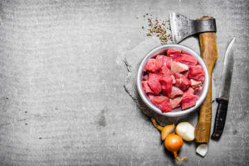 Chopped raw meat with an axe, cutting knife and spices.