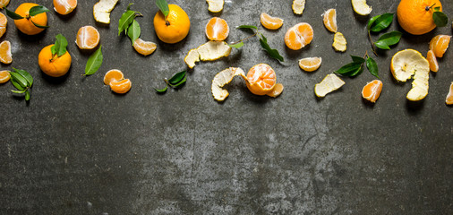 Fototapeta na wymiar Fresh tangerines with leaves . On stone background.