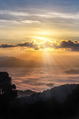Silhouette of Sunrise and mist with mountain.