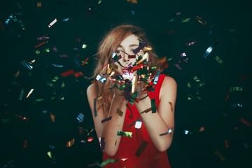 Portrait of woman blowing confetti
