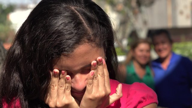Girl Grieving While Parents Watch
