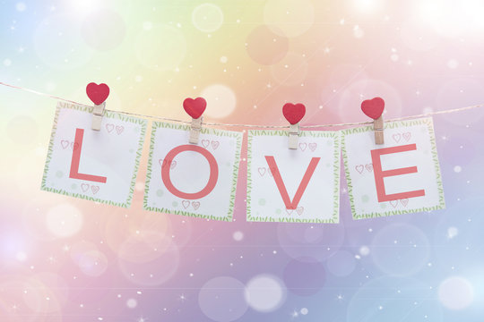 love symbol and hearts hanging on the clothesline with blank note for text