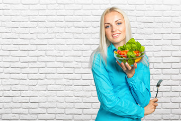 Beautiful girl eating fresh vegetable salad