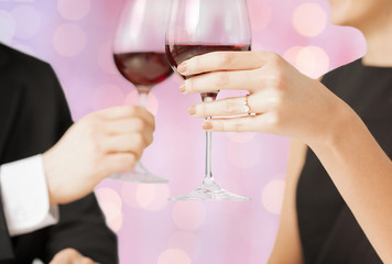 happy engaged couple clinking wine glasses