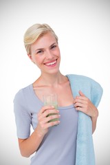 Composite image of fit woman holding healthy juice and towel