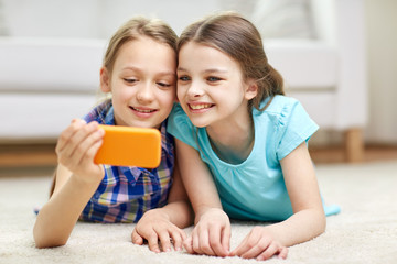 Obraz na płótnie Canvas happy girls with smartphone taking selfie at home