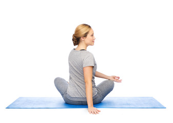 woman making yoga in twist pose on mat