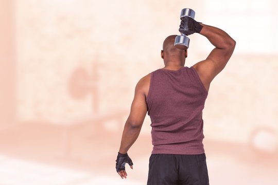 Composite image of fit man exercising with dumbbell 