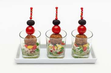Mini-Frikadellen-Spieße mit Tomate, Olive auf buntem Reissalat