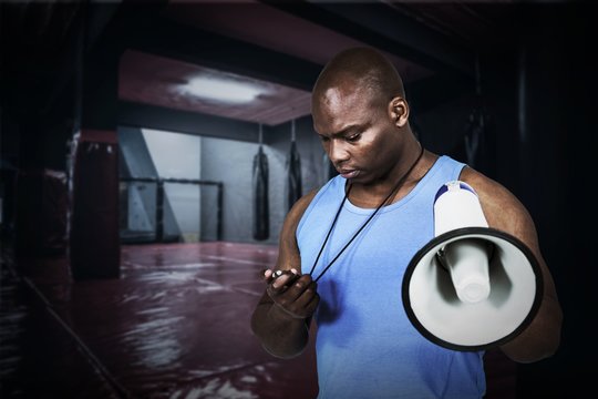 Composite image of fit trainer checking his stopwatch