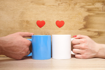 Hands loving couple holding cups and hearts on them