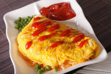 Japanese Omurice with rice, peas and ketchup close-up, horizontal
