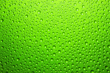 Fototapeta na wymiar Green water drops on glass surface texture.