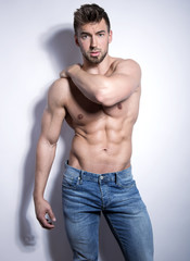 Fototapeta premium handsome young bodybuilder with toned body posing shirtless