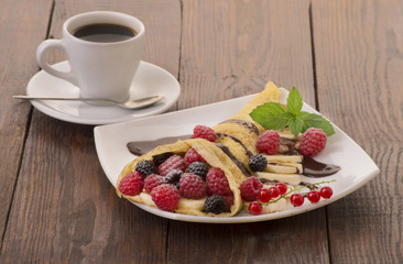 Cup of coffee and pancakes with berries