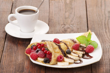 Cup of coffee and pancakes with berries