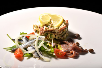 Fine dining seafood appetizer with Anchovies and octopus salad