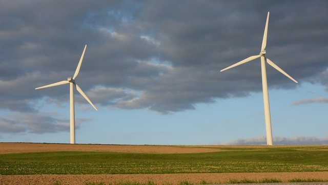 Two modern windmills rotating in high-wind