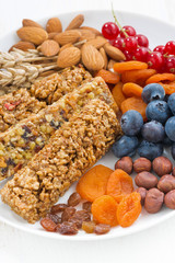 cereal muesli bars, fresh and dried fruit on a plate, closeup 