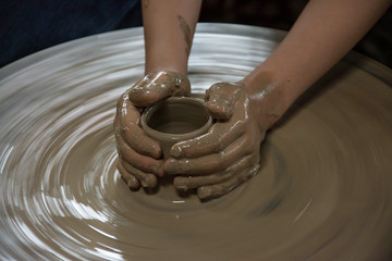 Hands working on pottery wheel 