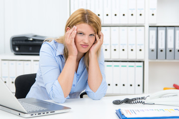 frau im büro hat kopfschmerzen