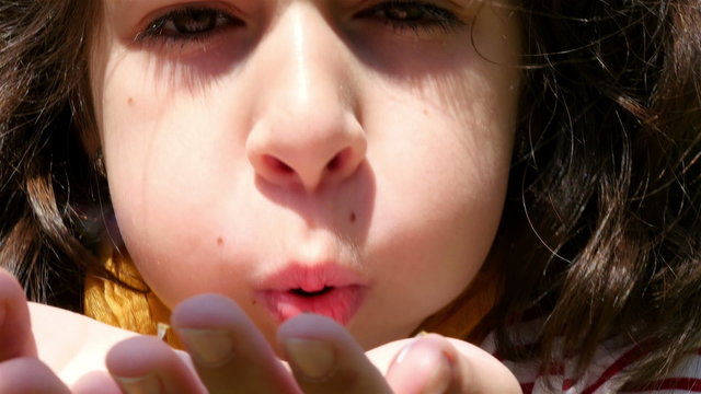 Girl holding in hands and blowing daysies
