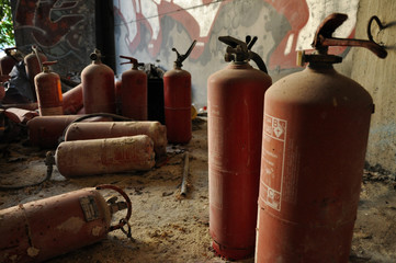 Algunos extintores gastados y apilados cubiertos de polvo 