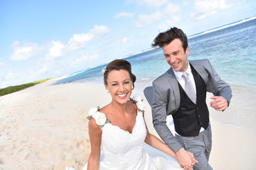 Just married couple running on a caribbean beach