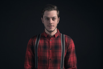 Fashionable man in red checkered shirt and braces.