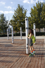 girl skating in-line in a park with loudspeakers
