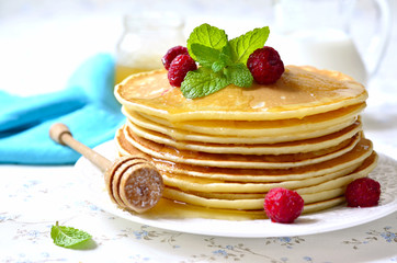Homemade pancakes with honey and raspberry.