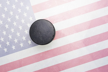 Naklejka premium old hockey puck is on the ice with united states of america flag
