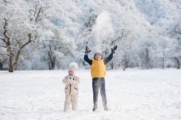 boy throws snow above the head being near the girl