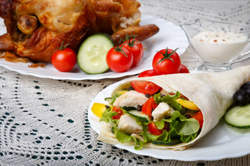 Shawarma on a white plate with a white sauce, doner kebab, traditional roll with meat and pita bread, selective focus on the filling