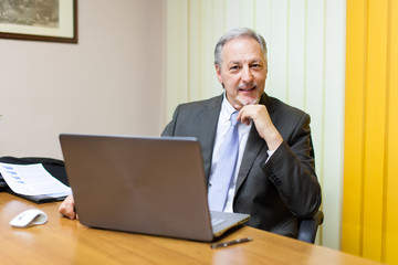 Portrait of a smiling senior businessman sitting in his office