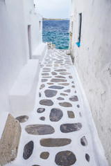 Traditional whitewashed alley of Mykonos with seaview, Greece