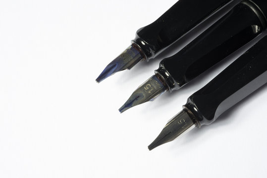 close up of used fountain pens isolated on white
