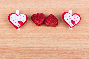 Four hearts on a light wooden background