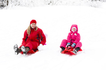 Fototapeta na wymiar mother and her little daughter with bobs in snow