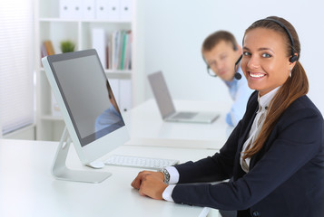 Fototapeta premium Happy female wearing headset and sitting on the desk