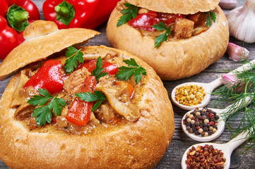 Stew made from meat, vegetables and mushrooms in a bread bowl