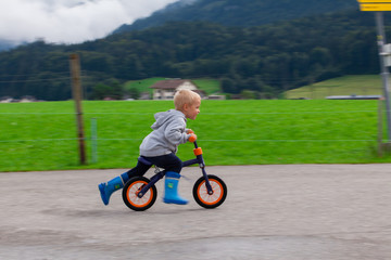 Little boy riding a bike on the water.