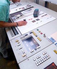 Operatore controlla con lente la qualità di stampa