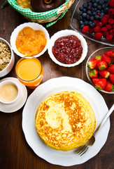 delicious pancakes on wooden table with fruits