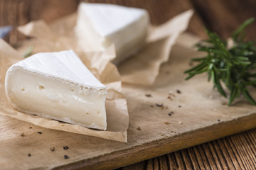Pieces of Camembert on wooden background