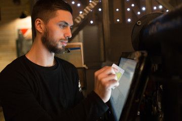 Cafe worker determines the value of the order at the computer