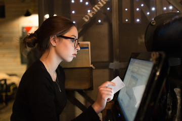 Cafe worker determines the value of the order at the computer